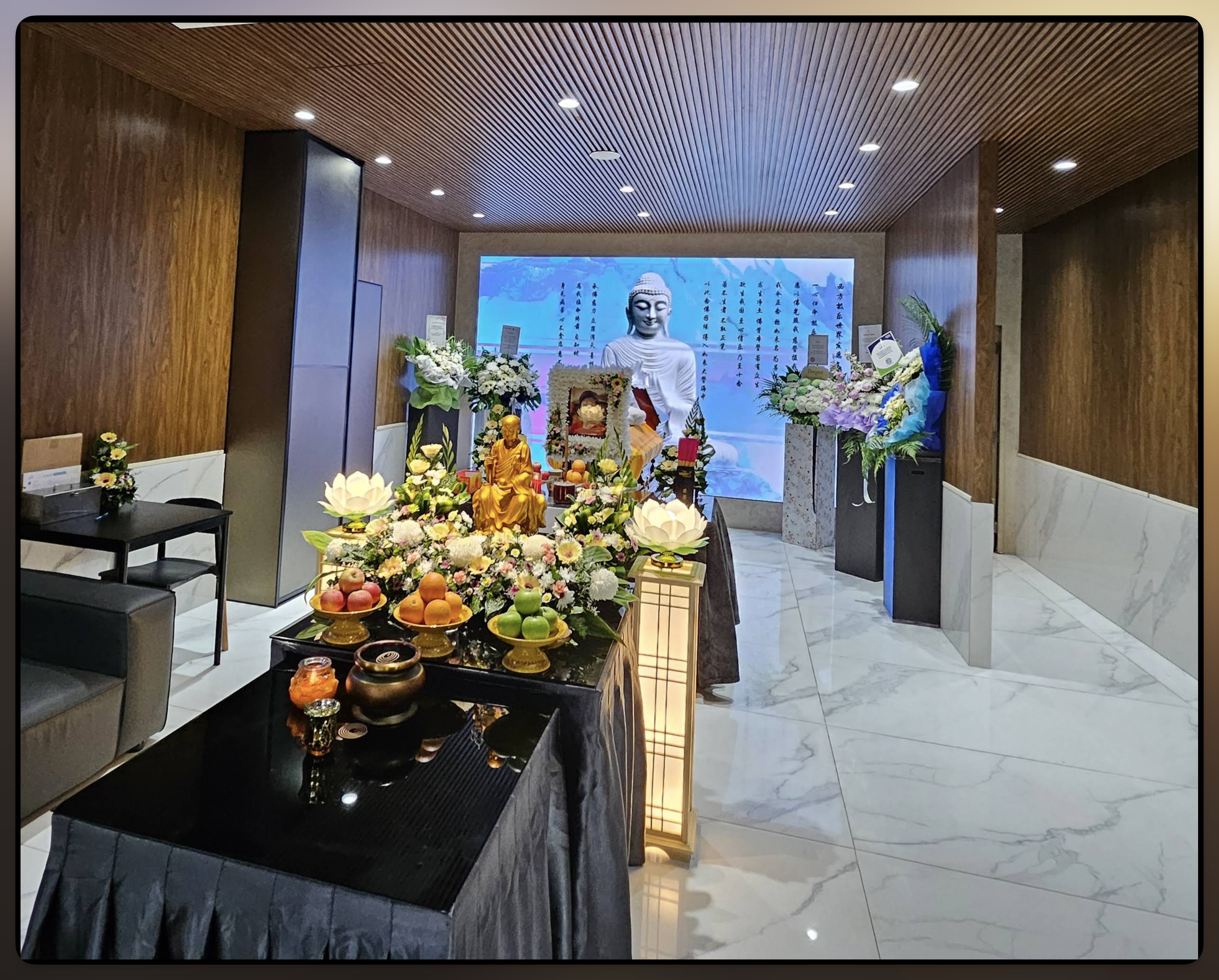 Funeral parlour altar with floral tributes, offerings and ceremonial figures