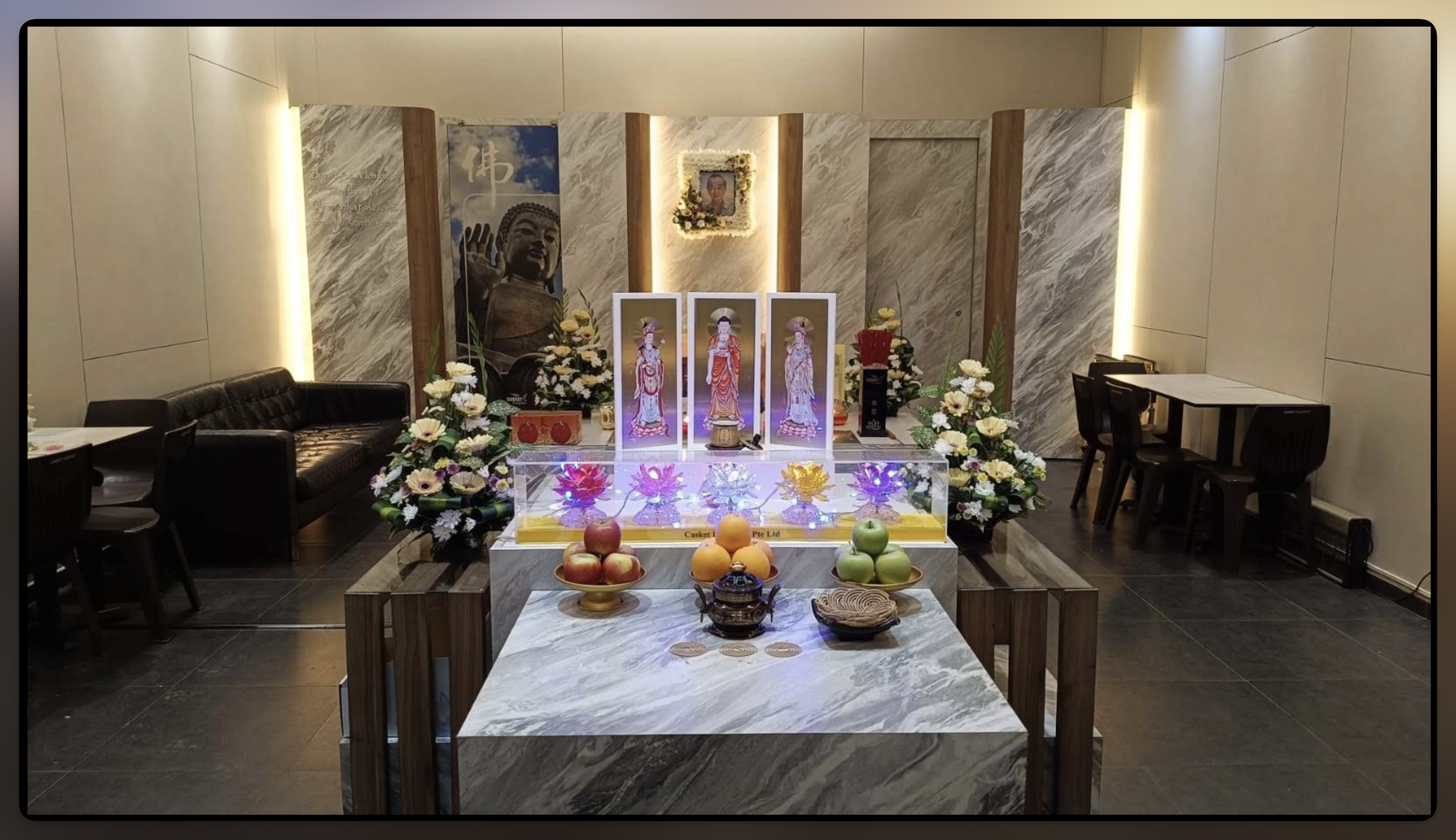 Buddhist funeral parlour altar with devotional images, flowers and offerings